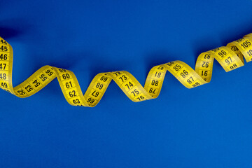 Yellow tape measure on the blue background