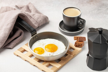 Fried eggs in a pan  and coffee on the table. Healthy breakfast