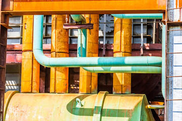 Fototapeta na wymiar Close up image of yellow and green steel pipes in the plant. Industrial concept.