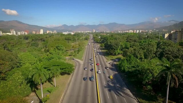 Aerial shot of a highway in Valencia, Carabobo, Venezuela, next to a green park