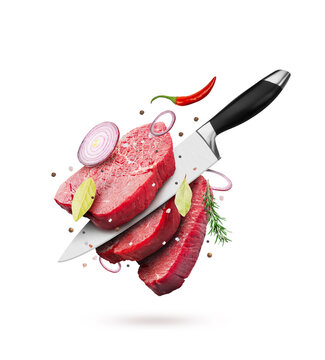 Pieces of raw beef steaks with knife, spice and pepper