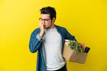 Russian Man making a move while picking up a box full of things isolated on yellow background...