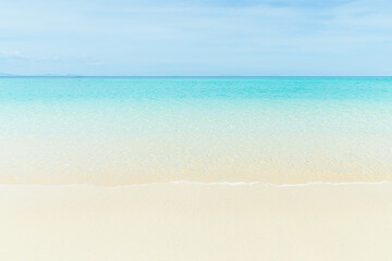 Soft blue ocean wave on clean sandy beach
