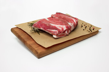 Carne su tagliere di legno con pepe e rosmarino