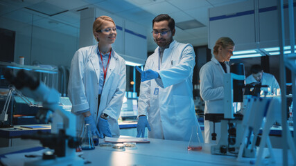 Female and Male Medical Research Scientists Have Conversation and Use Futuristic Virtual Interface...