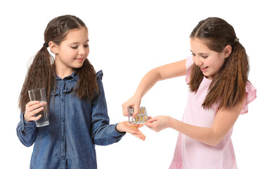 Little twin girls with fish oil on white background