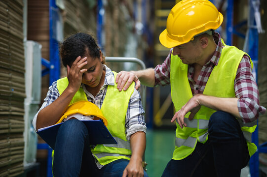 Young African female warehouse worker staff feeling sad and stress while Caucasian man consoling and encouraging due to been fired from job cause by company bankruptcy from coronavirus pandemic.