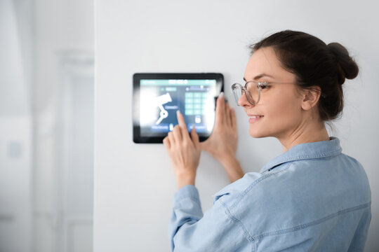 Woman Using Smart Home Security System Control Panel