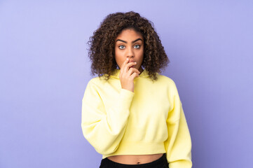 Young African American woman isolated on background surprised and shocked while looking right