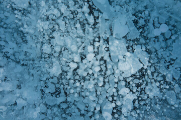 Fototapeta na wymiar bubbles in blue transparent ice on the lake