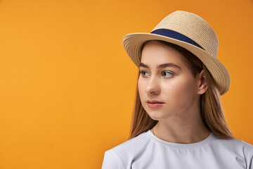 Portrait of joyful teenage girl showing, orange background with copy space