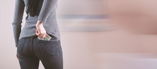 Woman hand putting money in jeans pocket