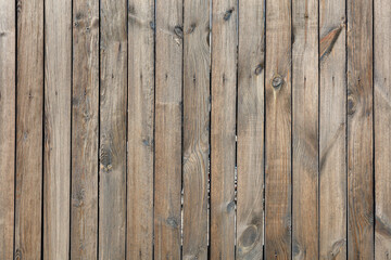 The texture of a wooden fence made of unpainted wood, weathered, nailed down with rusted nails. A high resolution.