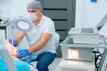 Male dermatologist working carefully with his patient