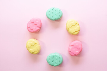 Minimalism concept of Easter candies on pink background.  Flat lay. Space for text. 