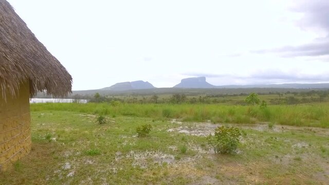 Pemon indigenous hut in Mayupa, Canaima, Venezuela, with amazing tepuy mountains at the back during a rainy day