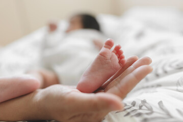 Feet of a newborn baby in the hands of parents, Cute baby feet.