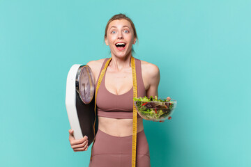 young pretty sport woman surprised expression and holding a scale and a salad