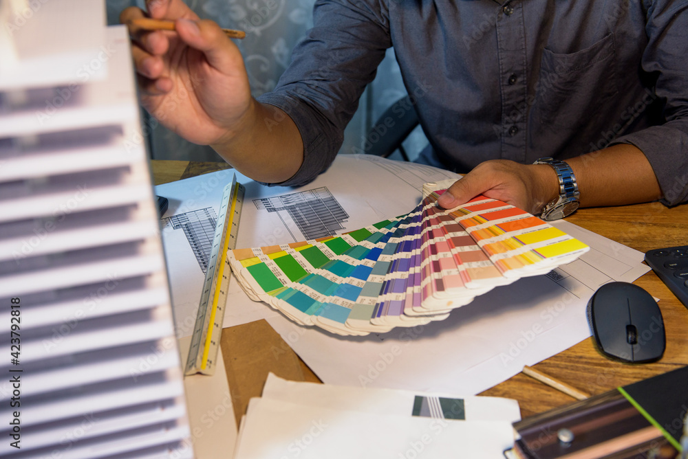 Aufkleber hand of architect-designer holding the color chart while thinking about concept of building and cons