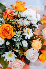 The table is decorated with orange and yellow flowers. gerbera, roses and rose mix. Gypsophila and calendula. Spring decor.