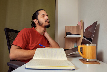 Young man tired working and studying at home. Home office man.