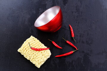 Chinese noodles with red pepper on black background