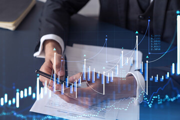 A client in formal wear reading the contract to invest money in stock market. Internet trading and...