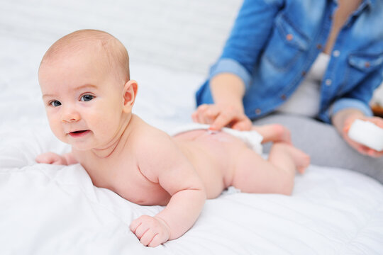 The Mother's Hand Applies A Moisturizing Baby Cream To The Baby Boy's Skin. Hygiene Of The Newborn Child.