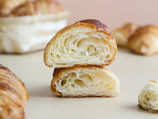 A cooked traditional French butter croissants cut to show an internal  fluffy of multiple layers. It is a buttery, flaky pastry made with a yeast leavened dough that has been laminated with butter