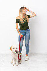 Young caucasian woman walking the dog isolated on white background smiling a lot