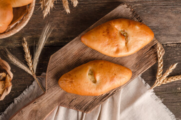 Appetizing fresh culinary pastry - pies with different fillings on a wooden