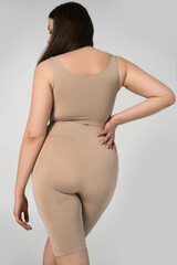 Obraz premium Full-figured brunette female posing on grey background