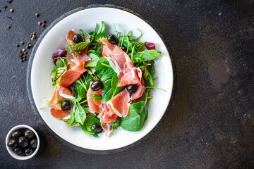 salad jamon prosciutto green leaves mix lettuce olives vegetables meat snack healthy meal top view...
