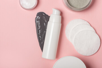 Cosmetic jar on the background of smeared cream or cosmetic face mask. A purifying and moisturizing clay mask. Top view, flat lay