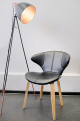 Floor lamp with black armchair. Interior studio for a photo shoot, video blogging. Director's chair concept. Minimalistic home interior.