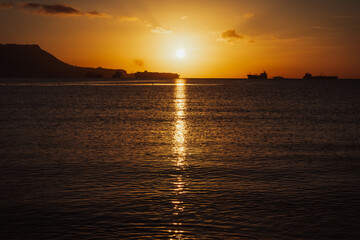 Golden sunrise over the sea and Gibraltar rock. Impressive ships are constantly traveling through the Bay of Algeciras, Andalusia, Southern Spain.