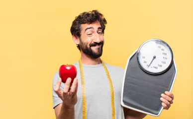 young crazy bearded man dieting happy expression and holding a scale and an apple