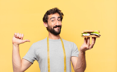 young crazy bearded man dieting happy expression and holding a sandwich