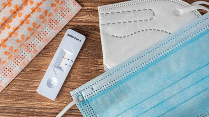 Negativer Corona-Schnelltest und Masken liegen auf einem Tisch