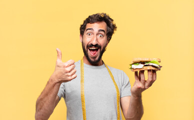 young crazy bearded man dieting happy expression and holding a sandwich