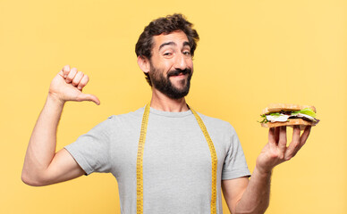 young crazy bearded man dieting happy expression and holding a sandwich