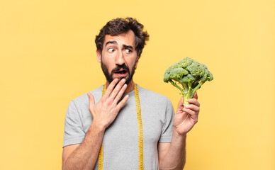 young crazy bearded man dieting scared expression and holding a cabbage