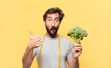 young crazy bearded man dieting surprised expression and holding a cabbage
