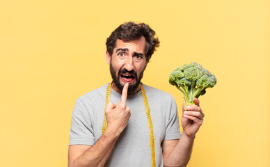 young crazy bearded man dieting sad expression and holding a cabbage