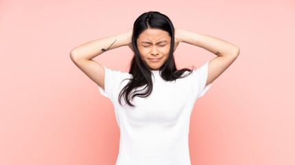 Teenager Chinese woman isolated on pink background frustrated and covering ears