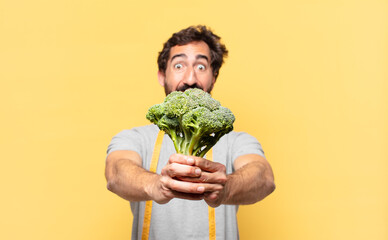 young crazy bearded man dieting surprised expression and holding a cabbage