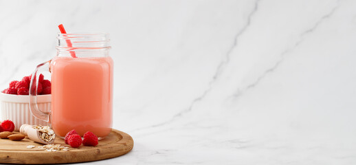 raspberries smoothie in a glass jar on the breakfast with raspberries, oatmeal. with copy space