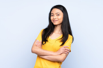 Obraz premium Teenager Chinese woman isolated on blue background keeping the arms crossed in frontal position