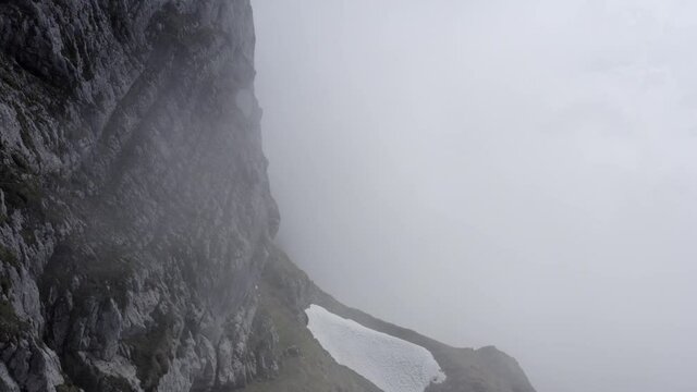 Aerial snowy mountain tops in the clouds Switzerland ungraded
