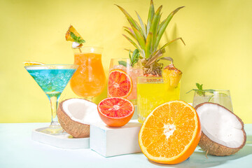 Colorful summer drinks set. Various bright alcohol cocktails and beverages, in different glasses, with tropical fruit on modern bright background copy space